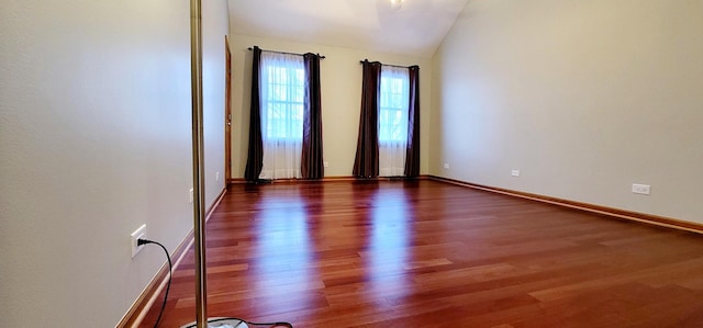 spare room with dark hardwood / wood-style floors and lofted ceiling