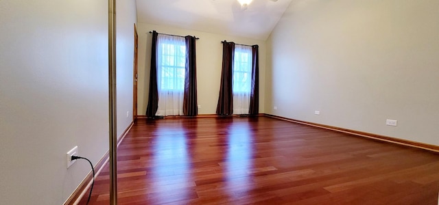 unfurnished room with dark wood-type flooring and vaulted ceiling