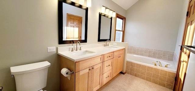 bathroom with tile patterned floors, tiled bath, vaulted ceiling, toilet, and vanity