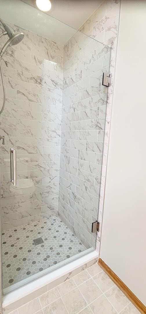 bathroom featuring tile patterned flooring and an enclosed shower