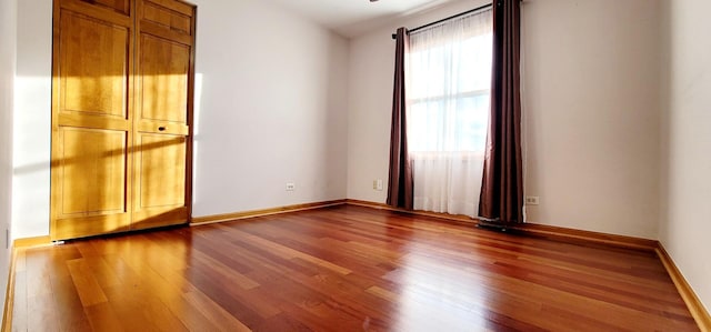 empty room featuring a wealth of natural light, hardwood / wood-style floors, and lofted ceiling