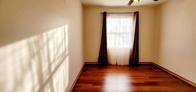 empty room with dark hardwood / wood-style flooring and ceiling fan