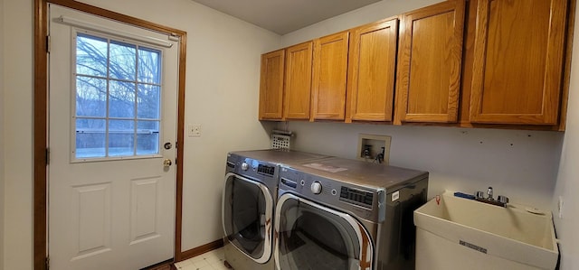 clothes washing area with cabinets, separate washer and dryer, and sink