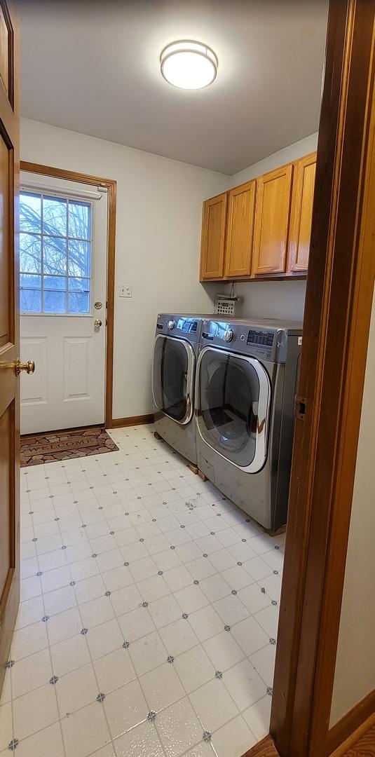 laundry room with washing machine and dryer and cabinets