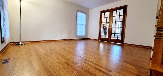 spare room with plenty of natural light, light hardwood / wood-style floors, and french doors