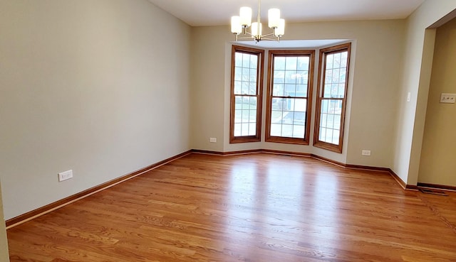 unfurnished room featuring light hardwood / wood-style flooring and a chandelier