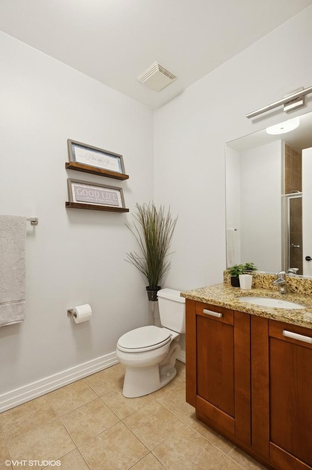 bathroom featuring tile patterned floors, a shower with door, vanity, and toilet