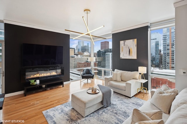 living room featuring hardwood / wood-style floors, floor to ceiling windows, a fireplace, and a chandelier