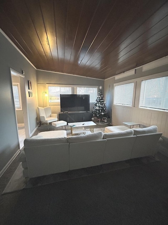 living room with crown molding, carpet floors, wood ceiling, and wood walls