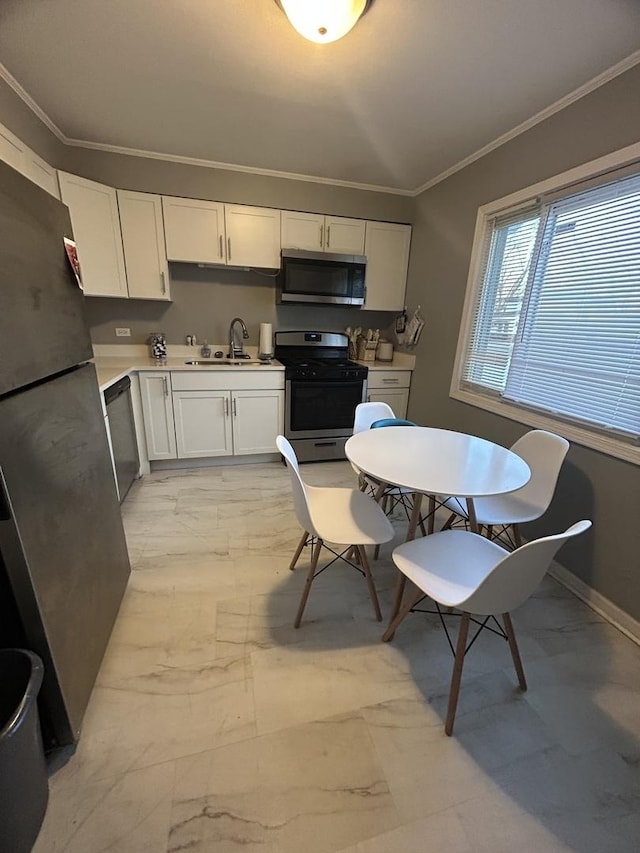 kitchen featuring sink, ornamental molding, white cabinets, and appliances with stainless steel finishes