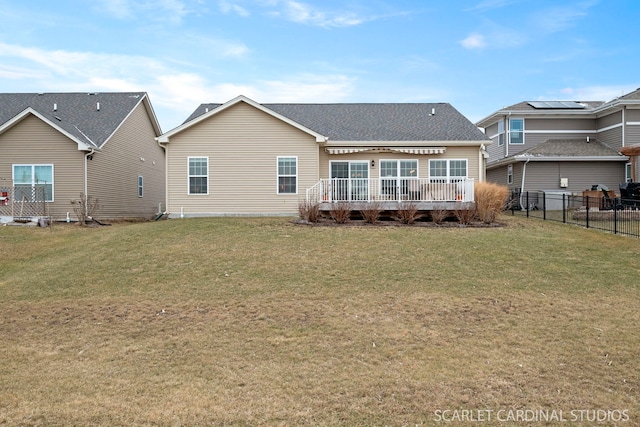 back of property featuring a lawn and a wooden deck