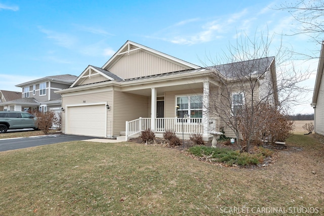 view of front of house featuring a front lawn, covered porch, and a garage