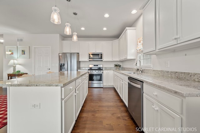 kitchen featuring sink, a center island, pendant lighting, white cabinets, and appliances with stainless steel finishes