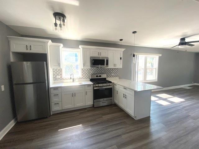 kitchen featuring kitchen peninsula, white cabinetry, and stainless steel appliances