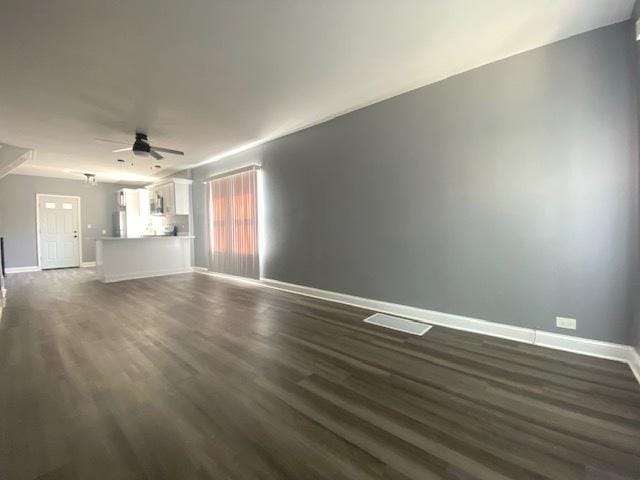 unfurnished living room with ceiling fan and dark hardwood / wood-style flooring