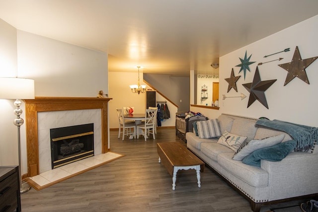 living room featuring a fireplace, hardwood / wood-style flooring, and a notable chandelier