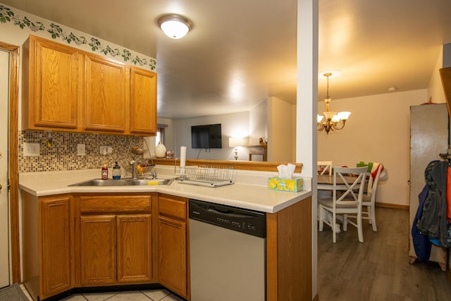 kitchen with decorative backsplash, stainless steel dishwasher, sink, a chandelier, and light hardwood / wood-style floors