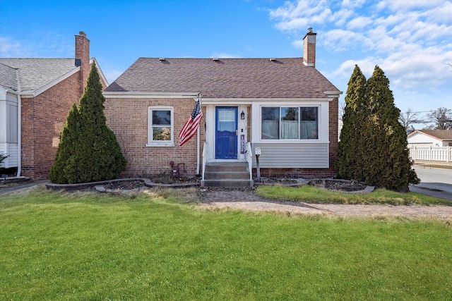 bungalow featuring a front yard, a chimney, brick siding, and a shingled roof