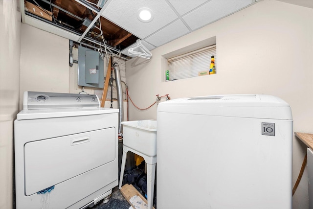 laundry room featuring electric panel and washer and clothes dryer