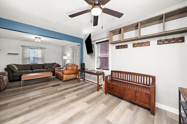 living area with visible vents, ceiling fan, baseboards, and light wood-style floors