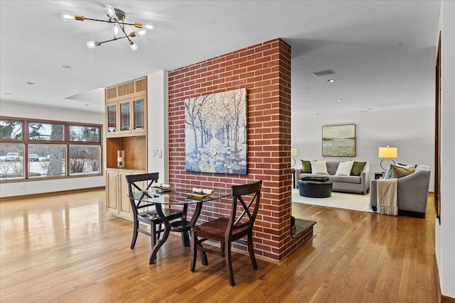 dining space featuring light hardwood / wood-style flooring and a notable chandelier