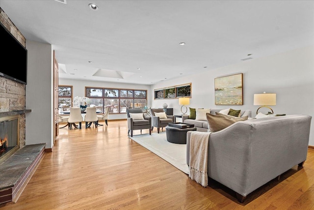 living room featuring a fireplace and light wood-type flooring