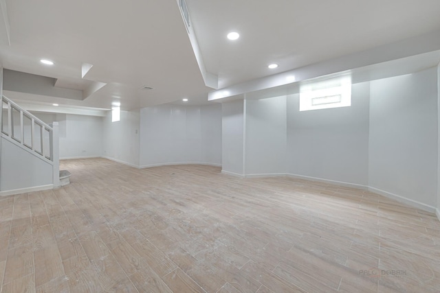 basement with plenty of natural light and light hardwood / wood-style floors