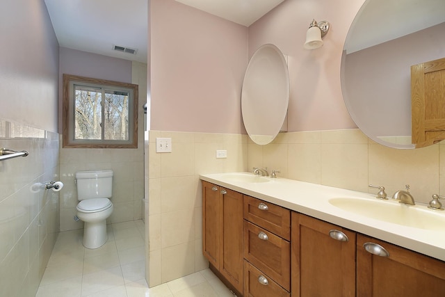 bathroom featuring toilet, vanity, tile walls, and tile patterned floors