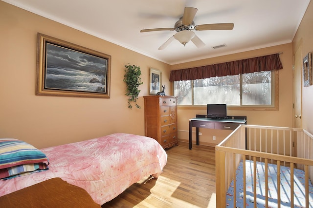 bedroom with ceiling fan, light wood-type flooring, and crown molding