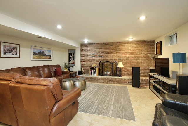 living room with light tile patterned floors, a brick fireplace, and brick wall