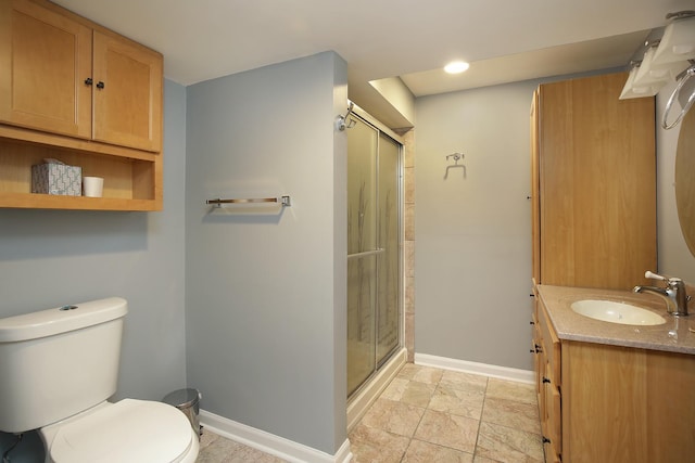 bathroom with vanity, toilet, and a shower with door