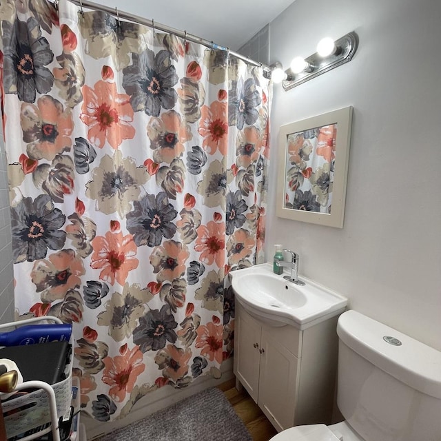 bathroom with hardwood / wood-style flooring, vanity, and toilet