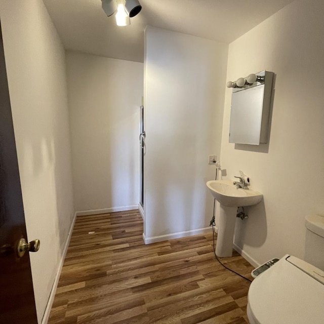 bathroom with hardwood / wood-style flooring, toilet, and sink