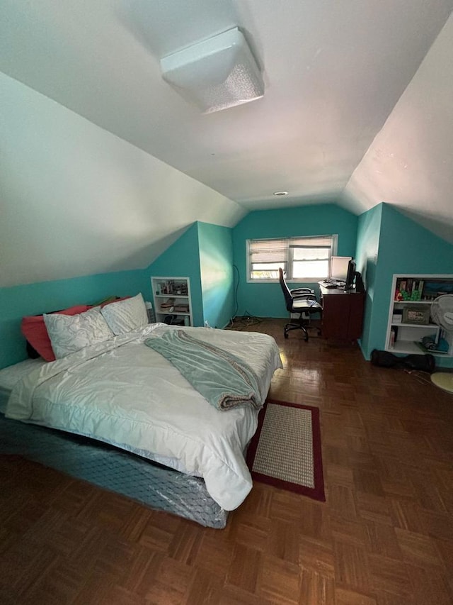 bedroom with dark parquet floors and vaulted ceiling