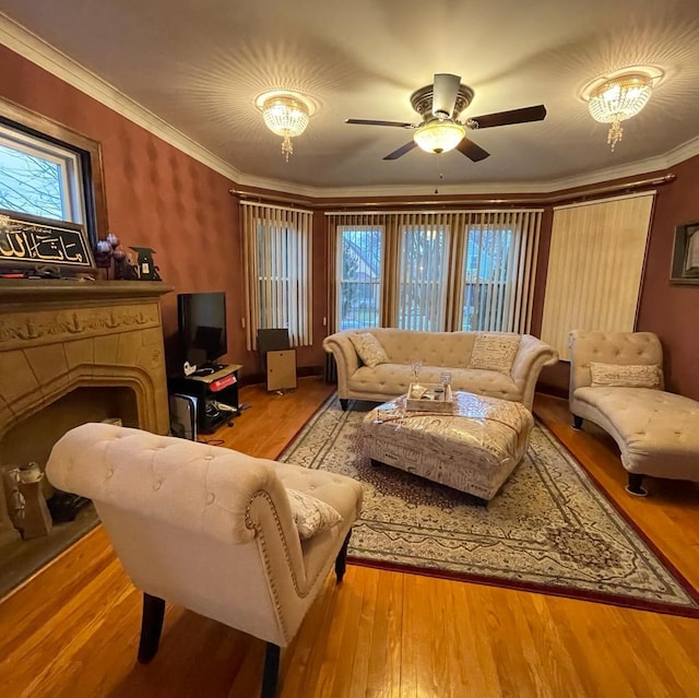 living room with ceiling fan with notable chandelier, light wood-type flooring, and crown molding