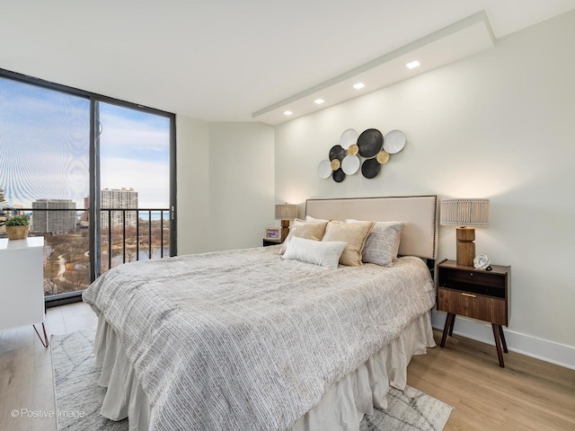 bedroom featuring light hardwood / wood-style flooring and a wall of windows