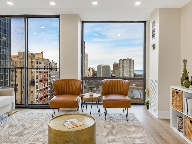 living area featuring light hardwood / wood-style floors and a wall of windows