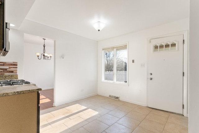 interior space featuring an inviting chandelier and light tile patterned flooring