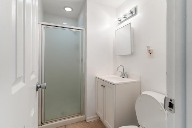 bathroom featuring tile patterned flooring, vanity, toilet, and a shower with door