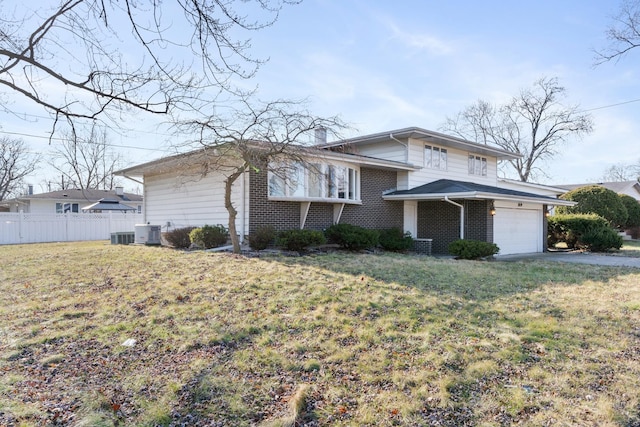 view of front of house with a front yard, central AC, and a garage