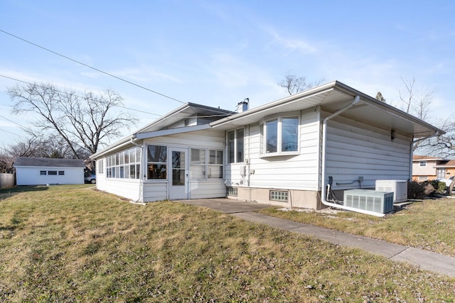 view of front of house with a sunroom, central air condition unit, and a front lawn