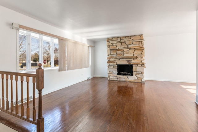 unfurnished living room featuring a fireplace and dark wood-type flooring