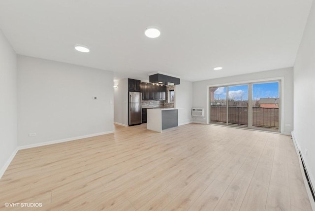 unfurnished living room with a wall mounted air conditioner and light wood-type flooring