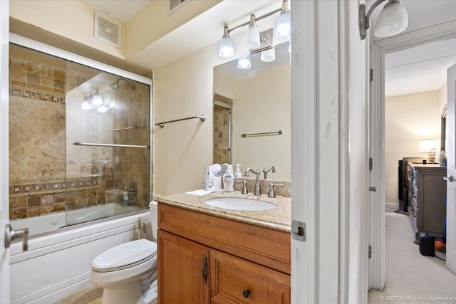 full bathroom with combined bath / shower with glass door, vanity, and toilet