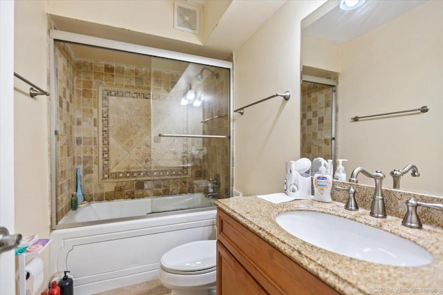 full bathroom featuring vanity, combined bath / shower with glass door, and toilet