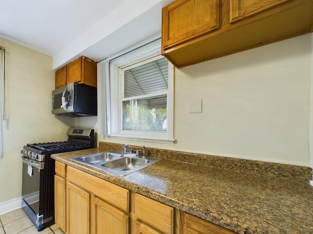 kitchen with appliances with stainless steel finishes, light tile patterned floors, and sink