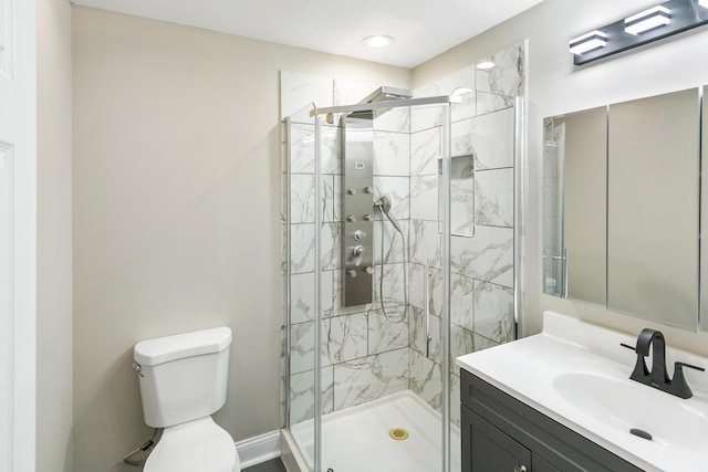 bathroom featuring vanity, toilet, and an enclosed shower