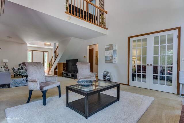 carpeted living room featuring french doors and a high ceiling