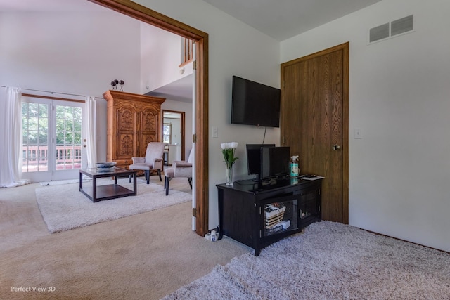 carpeted living room featuring a high ceiling