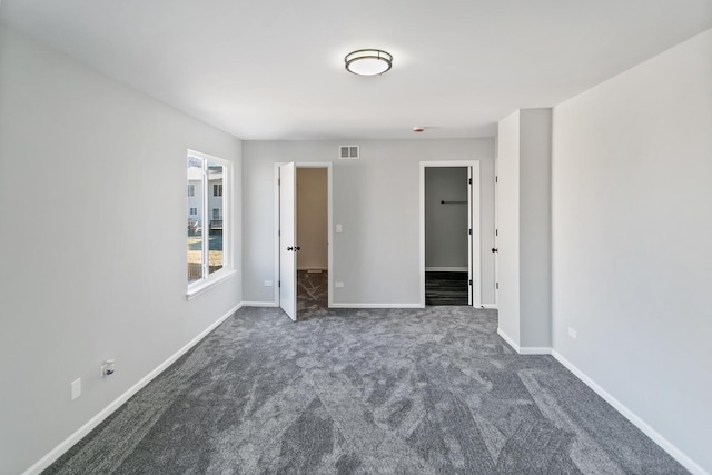 unfurnished room featuring dark carpet